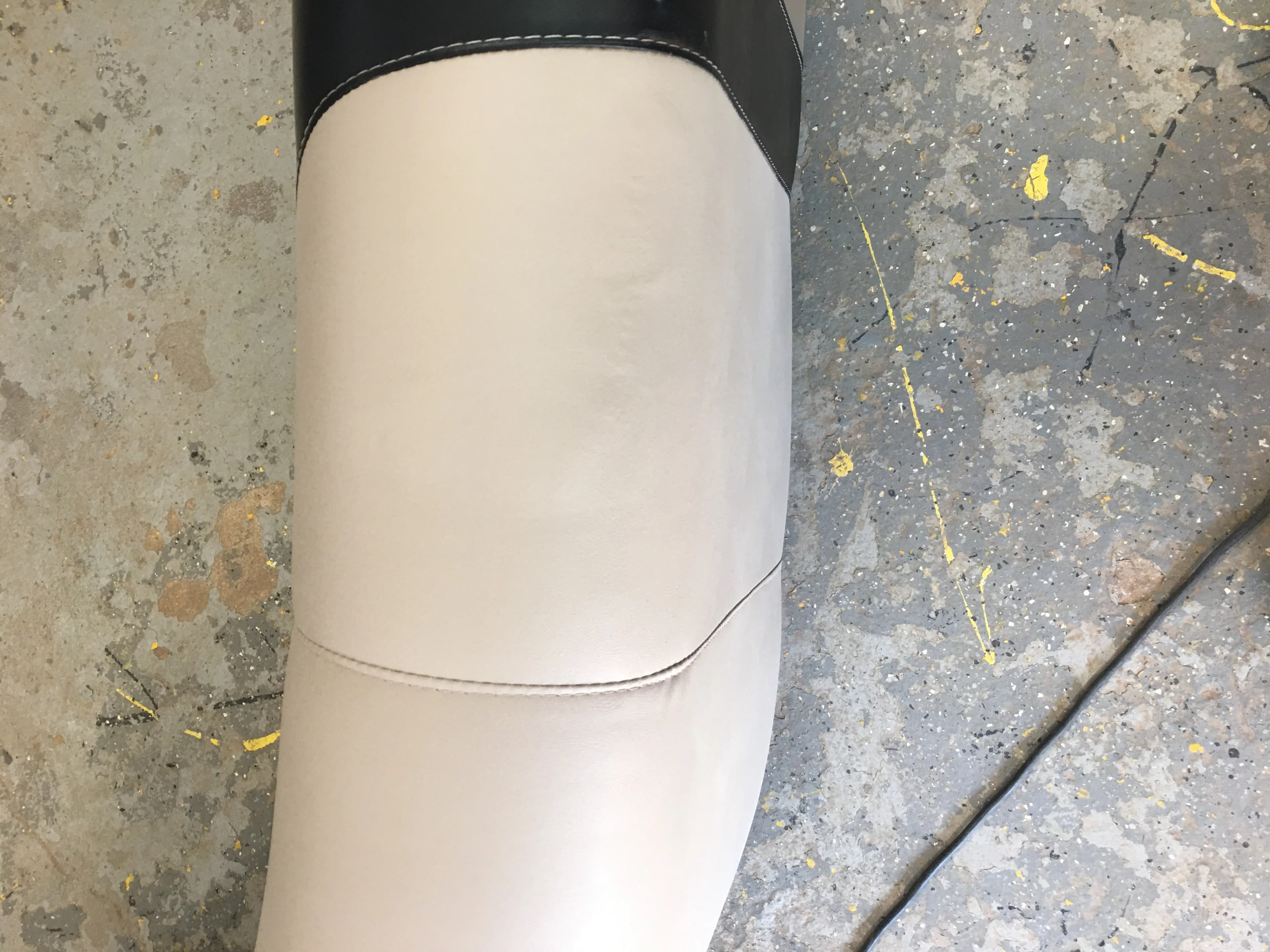 Repaired cream vinyl boat seat showing professional marine upholstery work