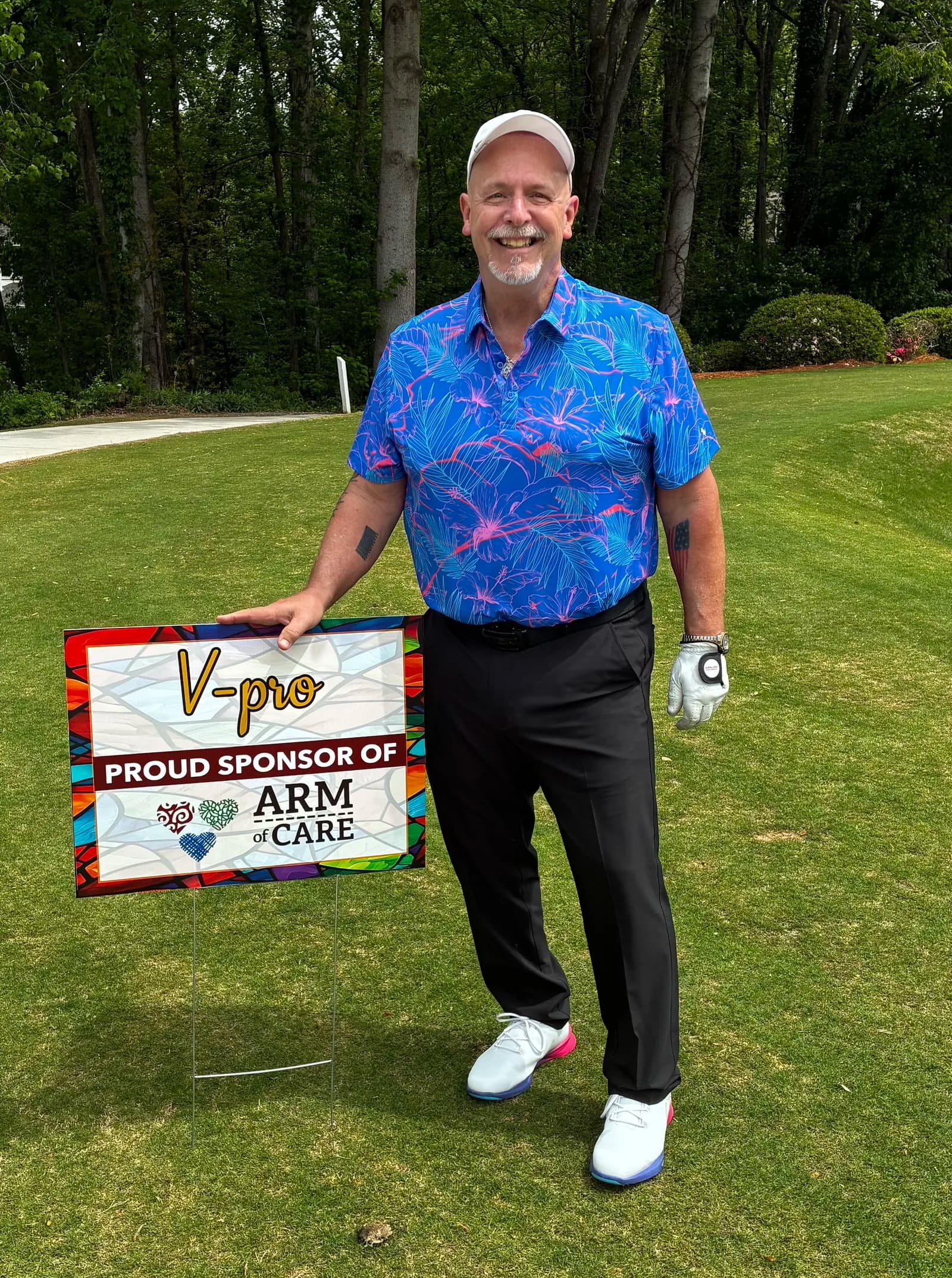 Brad Koplen at the ARM of Care golf fundraiser with the V-Pro sponsor sign
