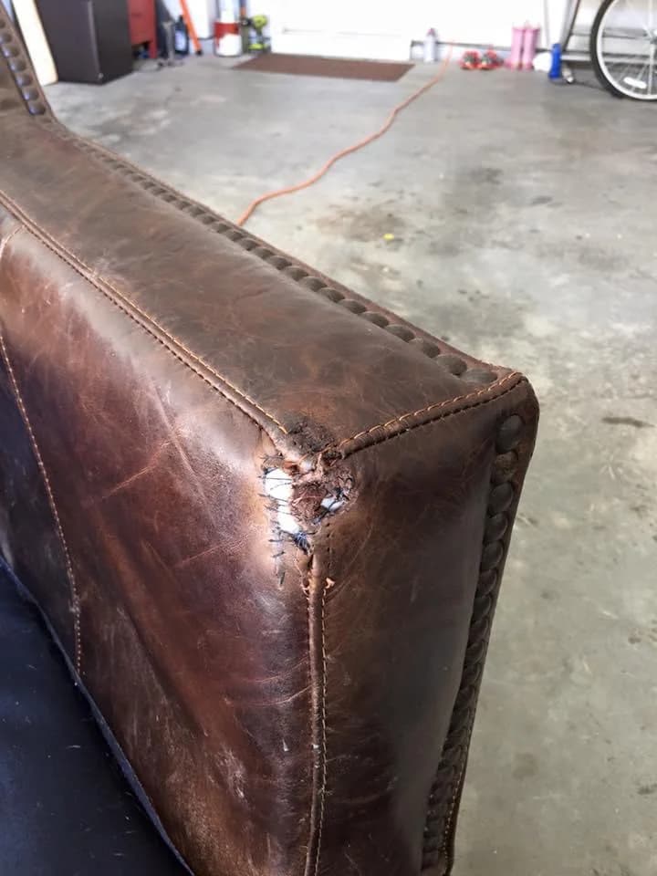 Brown leather sofa arm showing damage before repair
